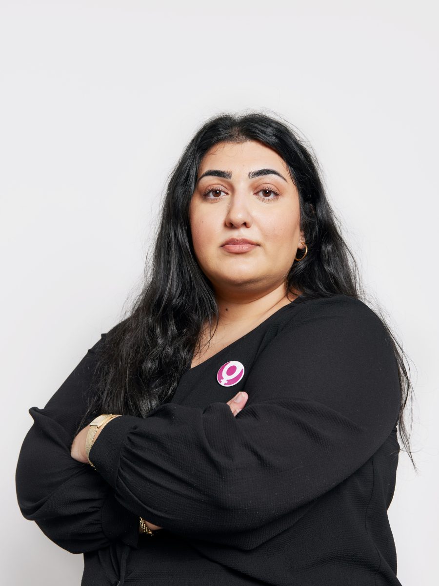 Roks ordförande Adine Samadi med armarna i kors framför en vit bakgrund